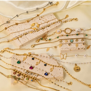 Detail of vintage gold bracelets with pearls and colorful gemstones on stone display