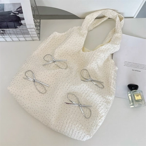 Dettaglio della borsa tote a pois con fiocchi d'argento metallizzato e tessuto plissettato