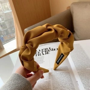 Détail du bandeau moutarde noué avec une étiquette faite main et une texture côtelée