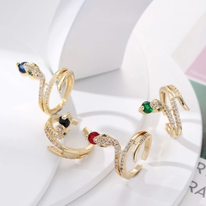 Detail of adjustable brass snake rings with colorful gemstones and pavé zircon crystals