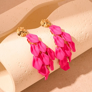 Macro view of pink acrylic petal tassel earrings with textured gold-tone stud detail