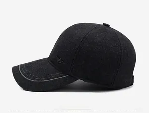 Detailed side view of charcoal grey wool baseball cap with metallic logo and stitched brim