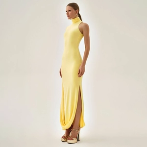 Detail view of the high side slit and soft fabric drape on a lemon yellow maxi dress