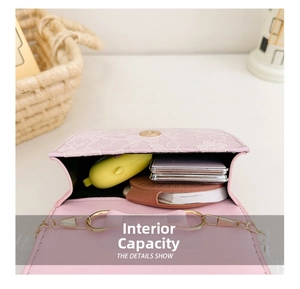 Detail view of pink bow bag interior showing space for earphones and small cosmetics