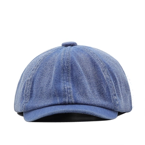 Detailed view of blue denim newsboy cap showing texture and stitching on the crown