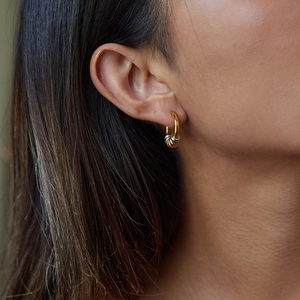 Nahaufnahme von minimalistischen Edelstahl-Creolen in Gold, Silber und Roségold am Ohr