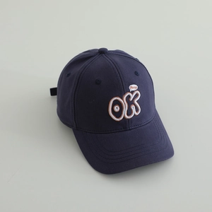 Detail of dark blue cotton baseball cap featuring orange OK 3D embroidery and cool bubble