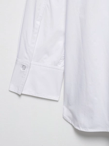 Detail of white cotton shirt cuff with matching button and clean double-needle stitching