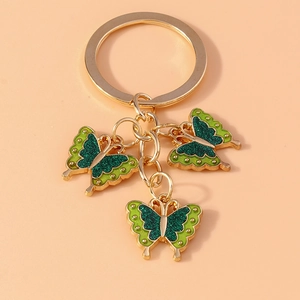 Detail of three green enamel butterfly charms with glitter on a golden keychain