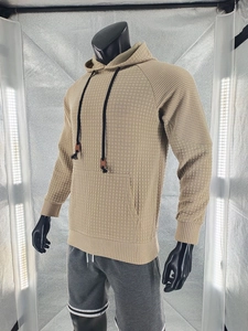 Detail von khakifarbenem Waffelstrick-Hoodie mit strukturierter Textur, Kordelzug und Kängurutasche