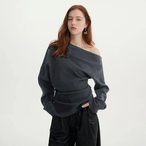 Detailed view of the elegant grey off-the-shoulder knitted sweater with long sleeves
