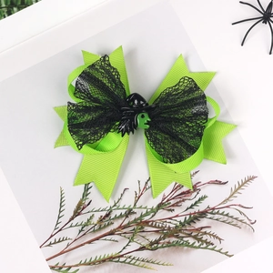 Detail von Halloween-Haarclip mit grünem Hexenkopf und schwarzer Spitzenschleife auf Weiß