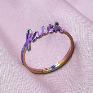 Detailed close-up of rainbow metal ring featuring a 3D Faith script and open band design
