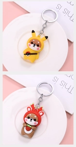 Close-up of cute Shiba Inu keychains in Pikachu and reindeer outfits with soft PVC texture
