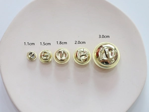 Cinq clochettes dorées de 1,1cm à 3,0cm présentées sur un plateau rose clair