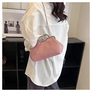 Dettaglio di una borsa da sera con strass rosa, chiusura in metallo argento e catena