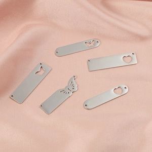 Polished silver stainless steel heart and butterfly hollow pendants on pink silk fabric