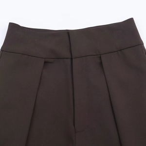 Vue détaillée du pantalon tissé marron foncé avec braguette cachée et plis à la taille