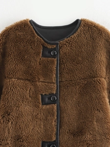 Nahaufnahme der braunen Plüschjacke mit schwarzen Lederbesätzen und Knopfdetails