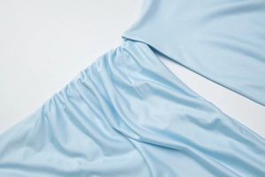 Détail du tissu bleu clair avec des fronces élégantes et une texture plissée fine