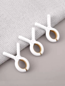 Detailed view of three white windproof laundry clips with non-slip silicone pads