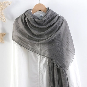 Detailed texture of dark grey cotton linen scarf with soft fringe edges and crinkled design