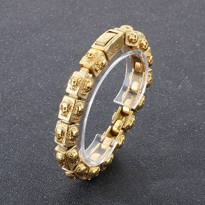 Detail of vintage gold skull chain bracelet with engraved square links and clasp