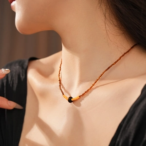 Detail of vintage tiger eye stone bead necklace with a large black centerpiece bead