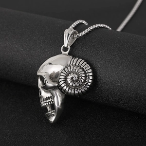 Macro shot of silver stainless steel pirate skull pendant with ram horns in punk style