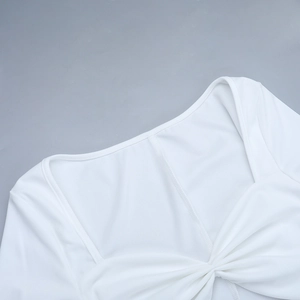 Detail of white square neck dress featuring an elegant knotted pleat and knit texture