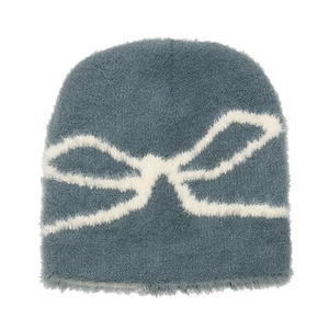 Detail of plush knitted beanie with white bow pattern in morandi blue-grey