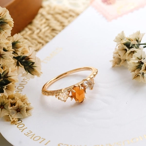 Detalle de anillo retro de plata 925 bañada en oro con granate y cristales blancos