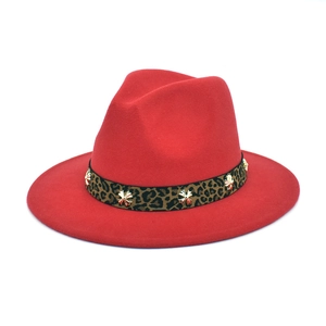 Detail of red wool fedora featuring a leopard print band and gold cross studs