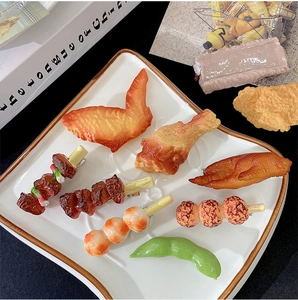Detailed set of realistic fake food hair clips featuring chicken wings and meat skewers