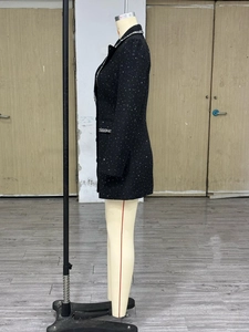 Detailed side view of black tweed jacket featuring sparkling sequins and decorative trim