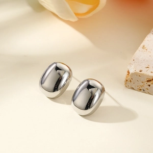 Macro detail of polished silver pebble stud earrings with a high-shine mirror surface finish
