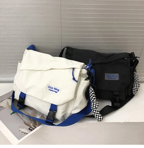 Front view of black and white canvas messenger bags with buckles and side pockets