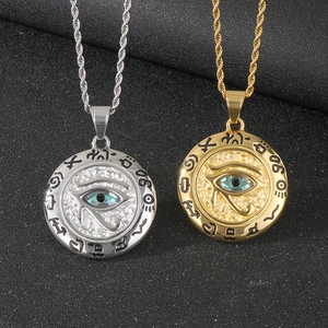 Détail de pendentifs Œil d'Horus en or et argent avec zircon bleu et chaînes torsadées