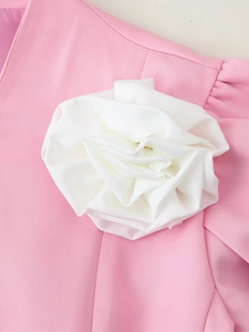 Dettaglio di un grande fiore in tessuto 3D bianco su un blazer rosa in tessuto saia