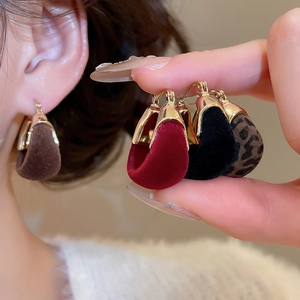 Detail of vintage velvet U-shaped earrings in brown, red, black, and leopard print styles
