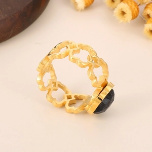 Detailed view of hollow floral gold ring with dark blue starry gemstone inlay