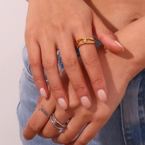 Detail of hand wearing 18K gold and silver layered hollow chain link rings