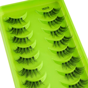 Macro detail of YK315 layered cross-braided black false eyelashes on green tray