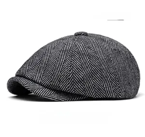 Detail of light gray newsboy cap featuring classic herringbone tweed fabric and top button