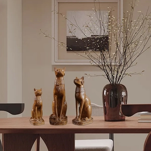 Three Nordic Bastet Egyptian cat statues in wood-colored resin on a wooden table decoration