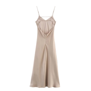 Detail view of champagne satin dress featuring backless design and crisscross straps