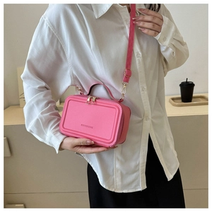 Detail of pink PU leather handbag with gold zippers and adjustable shoulder strap