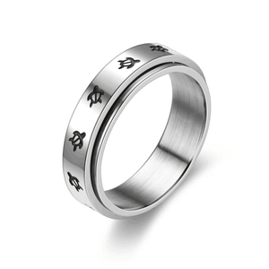 Gros plan sur une bague rotative en acier avec motifs de tortues gravés.