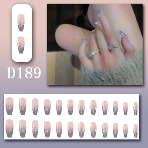 Detail von rosa-grauen Ombre-Klebenägeln mit 3D-Schleifen und Glitzer-Finish