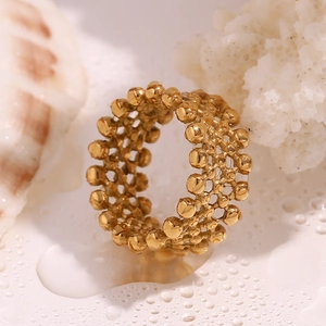 Detail of 18K gold plated ring with beaded mesh texture on water drops and shell background
